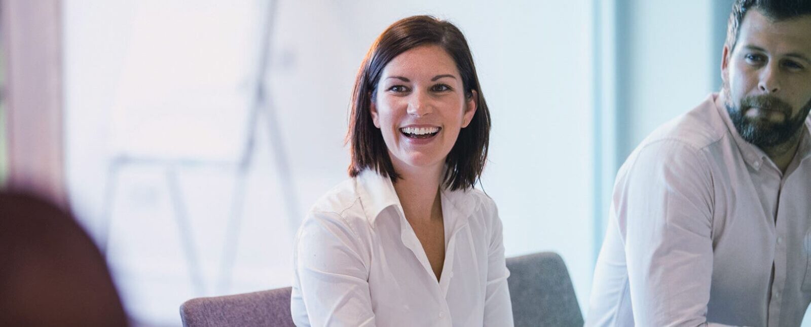 Neuven Home Image - woman in board room smiling